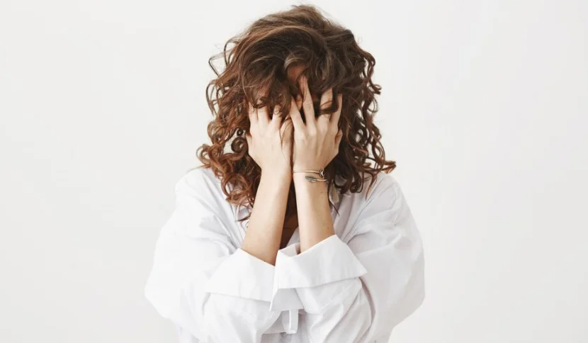 девушка с неврозом закрывает лицо